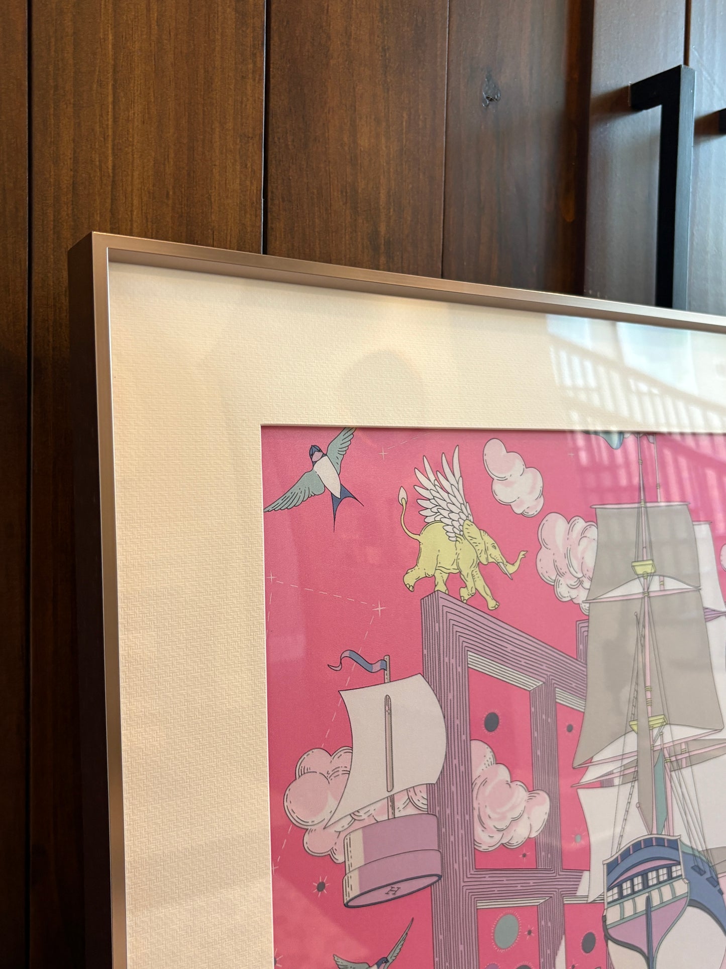 Silk scarf frame with couture purple gold matting displaying an Hermes silk scarf, wall-mounted for elegant presentation.